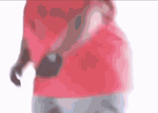 a man in a red shirt and grey shorts is holding a dumbbell in his hand .