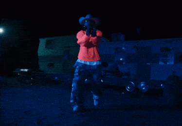 a person wearing a red jacket and cowboy hat
