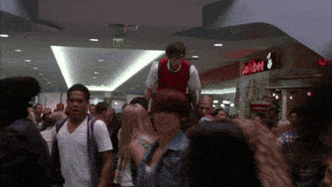 a group of people walking in a mall with a sign that says adobe