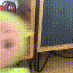 a blurred image of a person standing next to a wooden cabinet