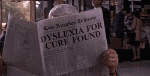 a man is reading a newspaper titled dyslexia for cure found