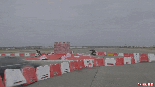 a video of a car driving around a red and white barrier with the words think jules on the bottom