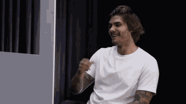 a man in a white shirt has a tattoo on his arm that says ' jesus ' on it
