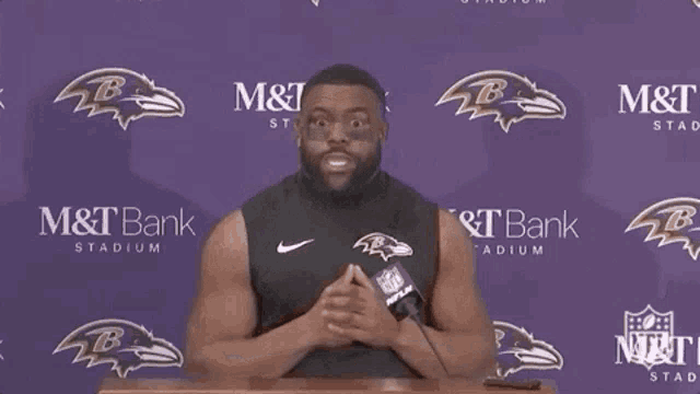 a man stands at a podium in front of a m & t bank sign