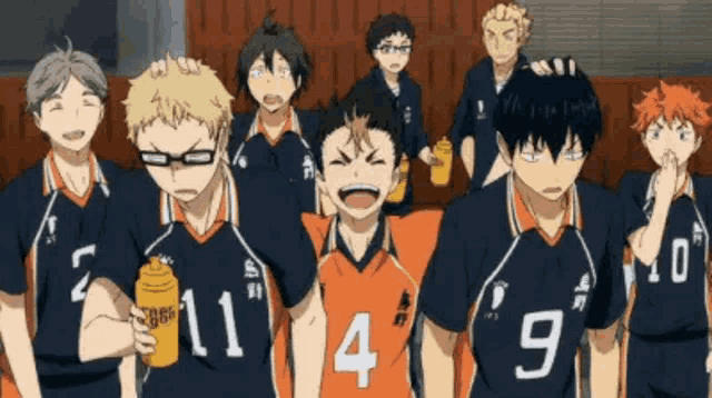 a group of volleyball players are standing next to each other in a gym .