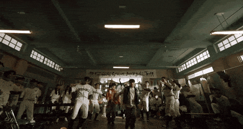 a group of baseball players are dancing in a locker room and one of them is wearing a shirt that says humbl
