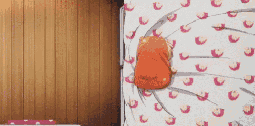 a cartoon character is laying on a bed with a blanket that has a pattern of cats on it
