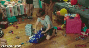 a boy is kneeling down in a messy room with balloons and presents and says vayagif.com at the bottom