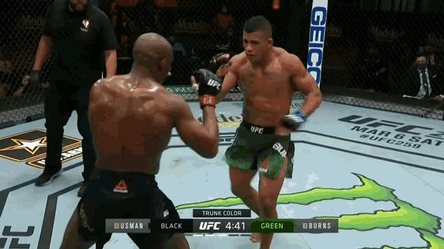 two men are fighting in a boxing ring with the ufc logo on the wall behind them