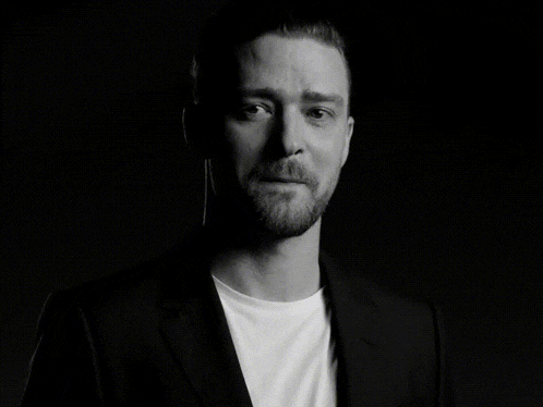 a black and white photo of a man in a suit and white t-shirt