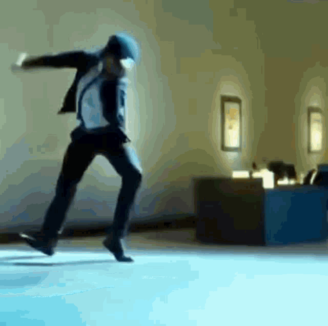 a man in a suit and tie is jumping in the air in a room .
