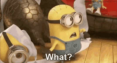 a minion is standing next to a roll of toilet paper .