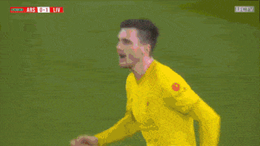 a man in a yellow shirt is screaming in front of a screen that says ars 0-1 liv