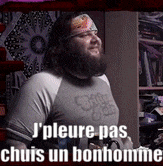 a man with a beard is wearing a shirt that says ' j'pleure pas chuis un bonhomme ' on it