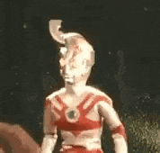 a statue of a superhero with a horn on his head is pointing at something .