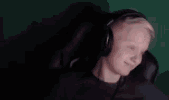 a man wearing headphones is making a funny face in a blurry photo .