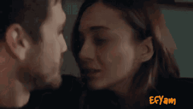 a man and a woman are kissing in a car with the word ecyam in the corner
