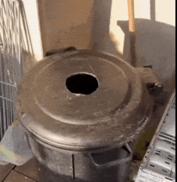 a large black trash can with a hole in the lid