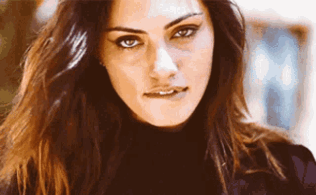 a woman with long hair is wearing a black turtleneck and making a silly face .