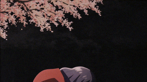 a person in a red jacket is standing in front of a tree with flowers