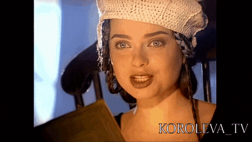 a woman wearing a knitted hat looks at the camera in a video from koroleva tv