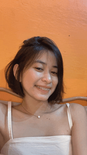 a girl with braces on her teeth is smiling