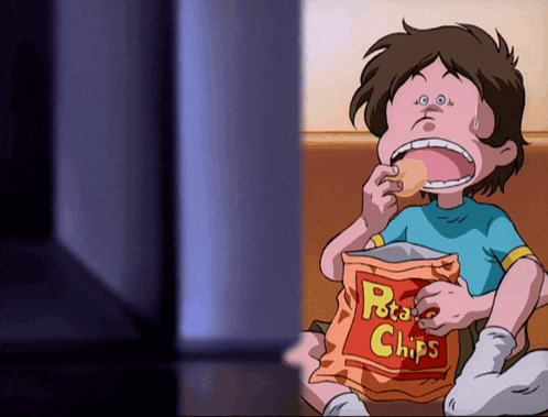 a boy is eating a bag of potato chips in front of a television