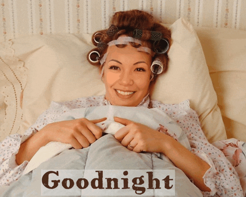 a woman with curlers in her hair is laying in bed with the words goodnight written above her