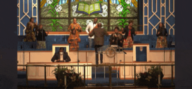 a group of people singing in front of a stained glass window with the word bible on it