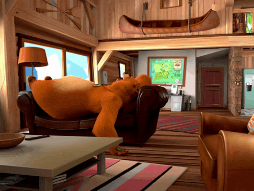 a bear is laying on a couch in a living room with a map on the wall