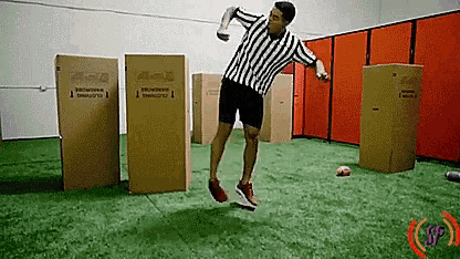 a referee is jumping in the air while holding a bottle of beer