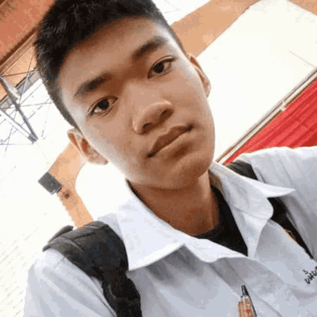 a young boy is taking a selfie with a backpack .