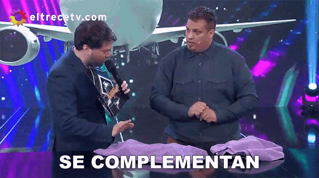 two men on a stage with a plane in the background and the words se complementan below them
