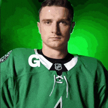a hockey player wearing a green jersey with the letter g on the front