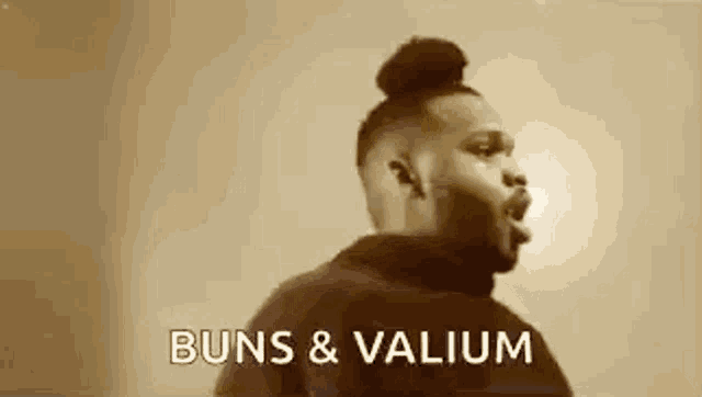a man with a bun on his head is standing in front of a wall and says `` buns & valium '' .