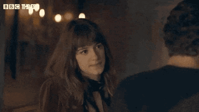 a man and a woman are looking into each other 's eyes with the bbc logo visible