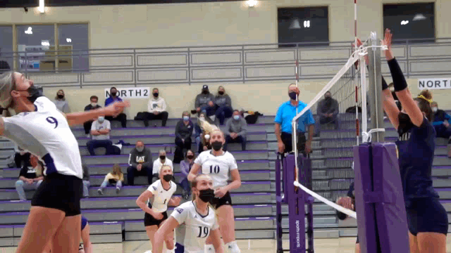 a volleyball game is being played in a gym with a sign that says north 2