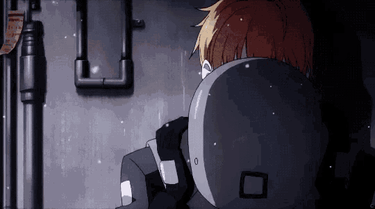 a man in a helmet is sitting in a dark room .