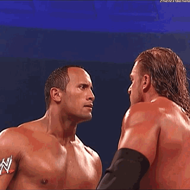 two wrestlers looking at each other with the letters n on their chest