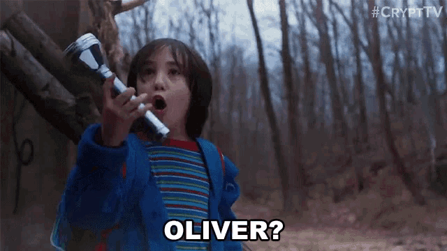 a young boy in a blue jacket is holding a flashlight and saying oliver