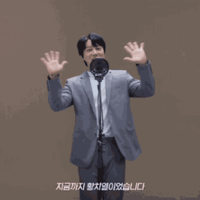 a man in a suit is waving at a microphone