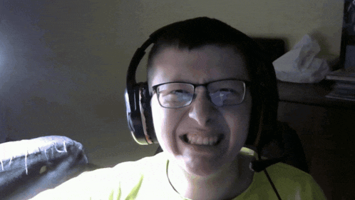 a man wearing glasses and headphones making a funny face