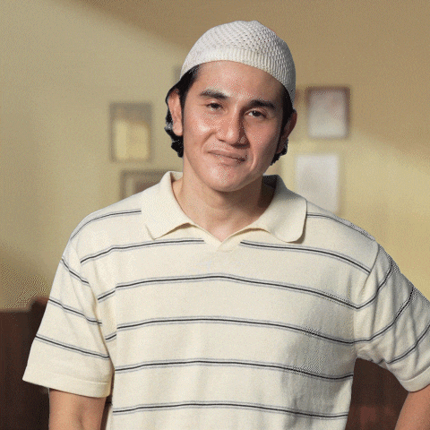 a man wearing a hat and a striped shirt smiles for the camera