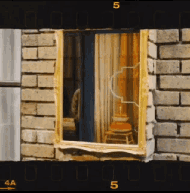 a brick wall with a picture frame on it and the number 5 on the bottom