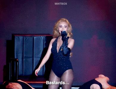a woman in a swimsuit singing into a microphone with the words bastards written below her