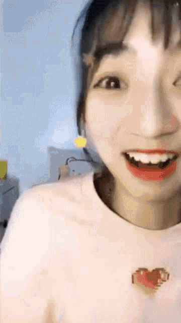 a close up of a girl 's face with a heart on her shirt