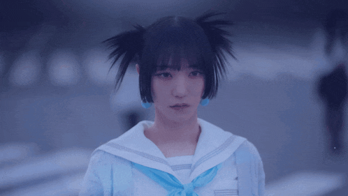 a girl with two pigtails and a blue scarf around her neck