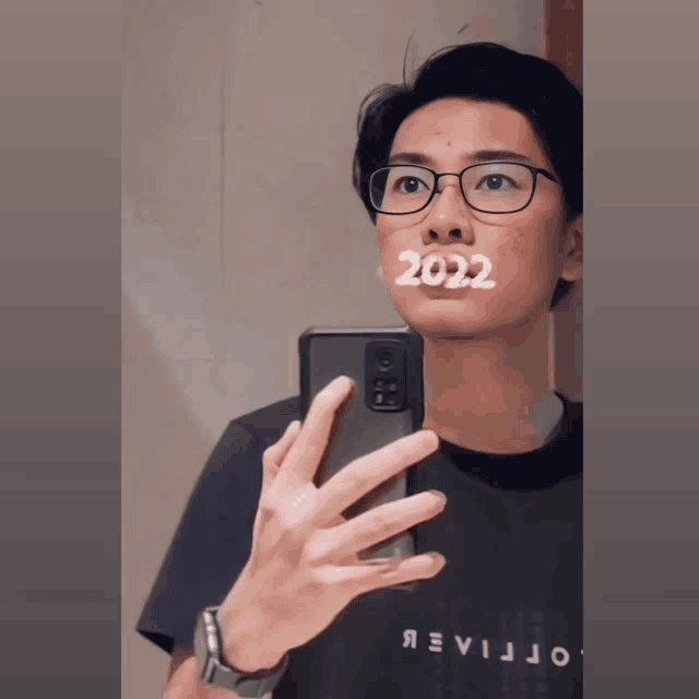 a man is taking a picture of himself with the year 2022 on his face