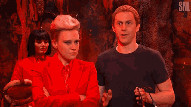 a man and a woman are standing next to each other with snl written on the bottom of the screen