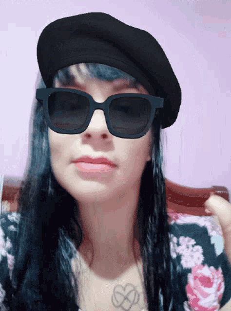 a woman wearing a black beret and sunglasses